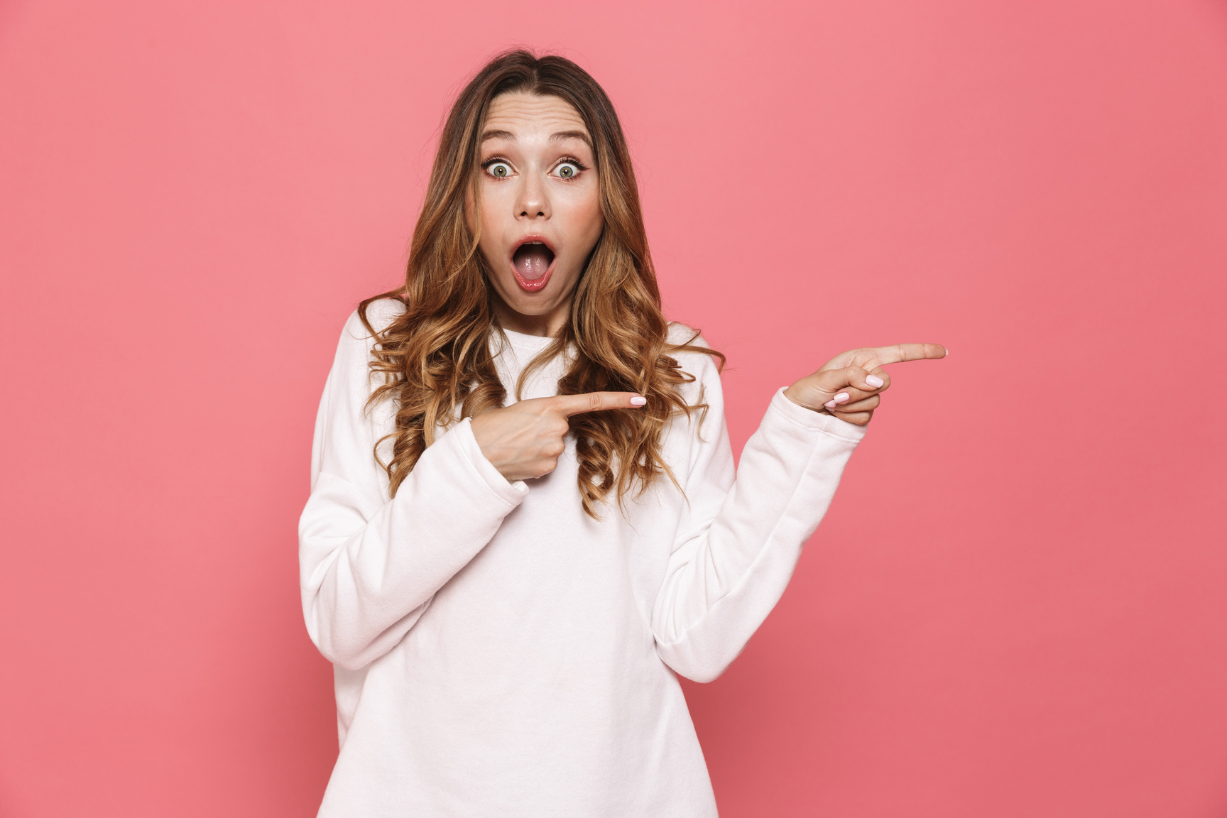 Portrait of a Surprised Young Casual Girl Pointing